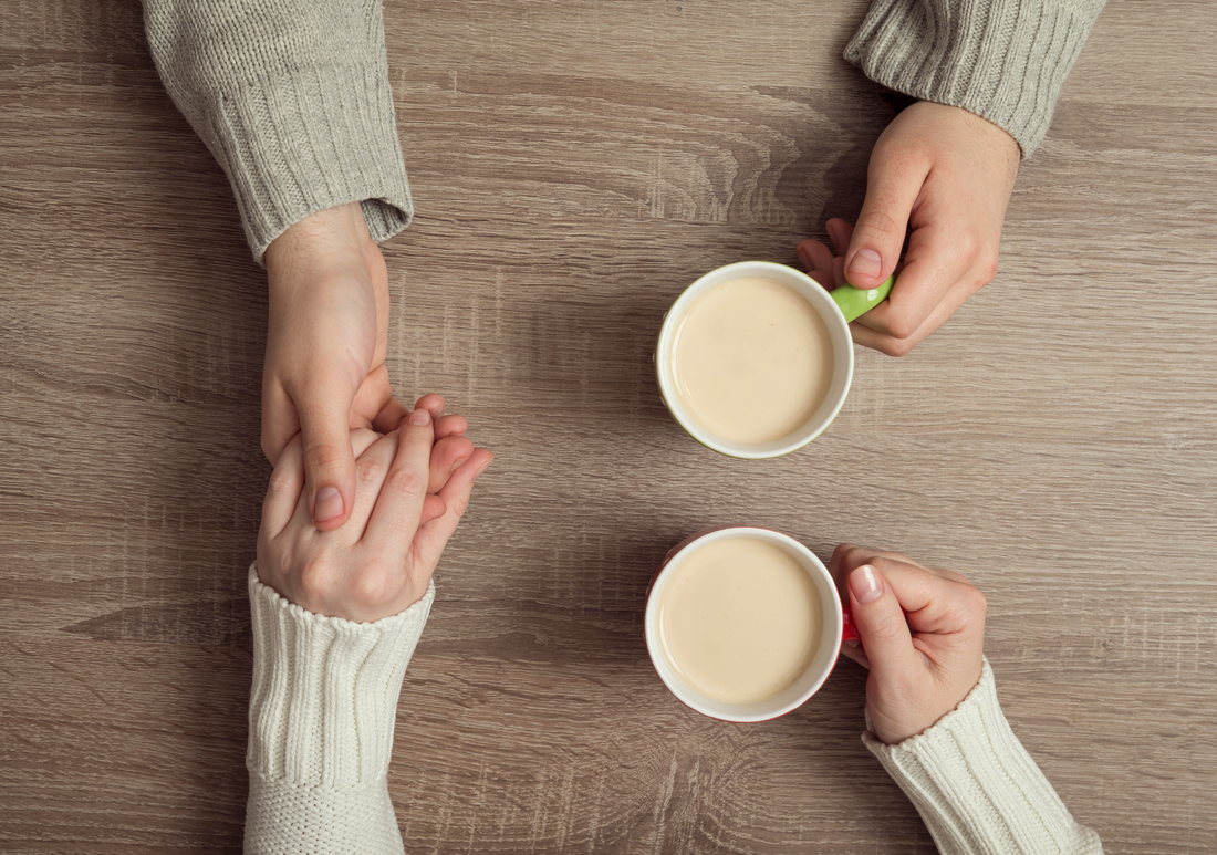 twice-compassionate neurodiverse couple, image holding hands with coffee cups